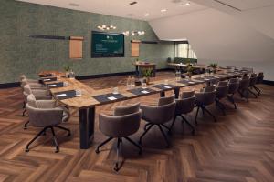 een grote vergaderzaal met een lange tafel en stoelen bij Van der Valk Hotel Stein Urmond in Urmond