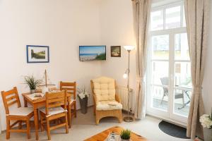 Una sala de estar con una mesa y sillas y una ventana. en Villa Zur Alten Post, en Kühlungsborn