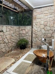 a bathroom with a stone wall and a wooden sink at Casablanca Villas CB in Brumadinho +28 photos