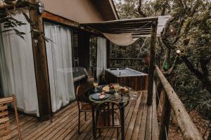 a wooden deck with a table and chairs on it at Casablanca Villas CB in Brumadinho