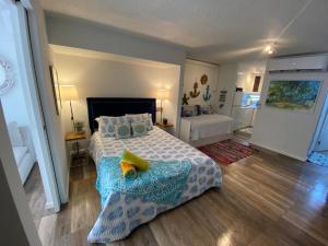Schlafzimmer mit einem Bett mit blauer Decke in der Unterkunft KASA Ocean Breeze - Cabana Studio Apartment BEACHFRONT CONDO POOL in San Juan