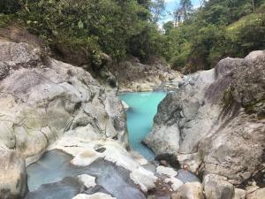 a pool of blue water in the middle of rocks at Casa Mandala by Dreamcatcher in Sarchí