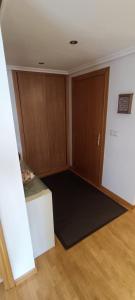 um quarto vazio com uma porta e um tapete preto em Piso céntrico al lado de Oviedo em Lugones