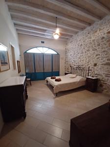 sypialnia z łóżkiem i kamienną ścianą w obiekcie Villa Aposperitis w mieście Panormos