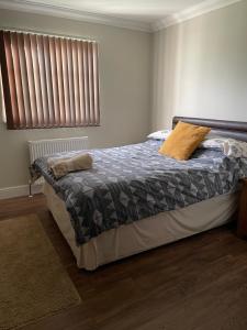 a bedroom with a bed with a gray blanket and a window at OAK LODGE in Tillingham