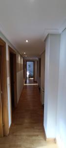 an empty hallway in a building with wood floors at Piso céntrico al lado de Oviedo in Lugones