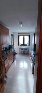 uma grande cozinha com uma mesa no meio em Piso céntrico al lado de Oviedo em Lugones
