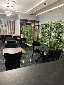 a restaurant with tables and chairs and plants at Emsa Otel Maltepedeki Eviniz in Istanbul
