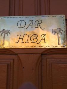 een bord op een deur met palmbomen erop bij DAR HIBa in Marrakesh