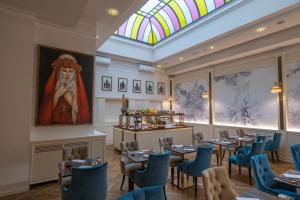 a dining room with tables and chairs and a stained glass window at Golden Tower Hotel & Spa in Florence