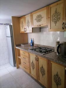 een keuken met houten kasten en een fornuis met oven bij DAR HIBa in Marrakesh