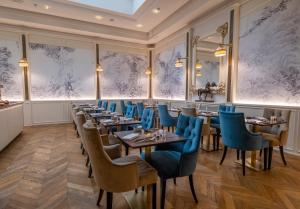 a dining room with tables and blue chairs at Golden Tower Hotel & Spa in Florence