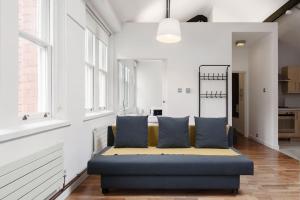 a living room with a blue couch and windows at City Superhost - Northern Quarter Loft Conversion in Manchester