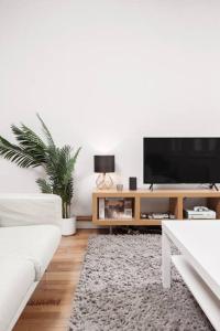 a living room with a white couch and a flat screen tv at City Superhost - Northern Quarter Loft Conversion in Manchester