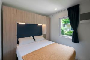 拉齊塞的住宿－奧羅湖濱露營酒店，一间卧室设有一张床和一个窗口