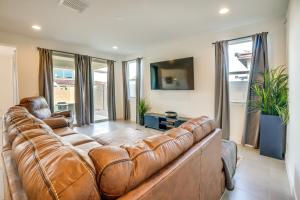 a living room with a brown leather couch at Newly Built Glendale Home 5 Mi to Westgate! in Glendale