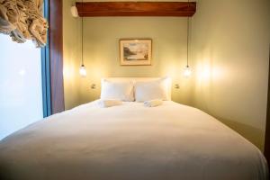 a bedroom with a large white bed with two pillows at Luxury Roof Terrace Townhouse in Manchester