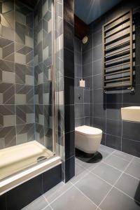 a bathroom with a shower and a toilet and a sink at Luxury Roof Terrace Townhouse in Manchester