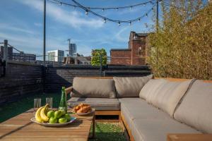 Luxury Roof Terrace Townhouse في مانشستر: أريكة وأوعية من الفواكه على الفناء