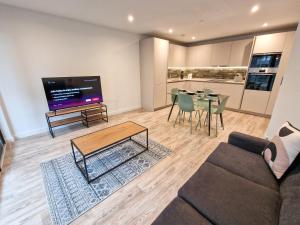 a living room with a couch and a tv at Free Parking - Stunning Canal Facing Apartment in Manchester