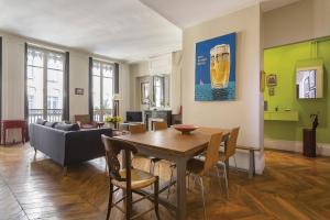 uma sala de estar com uma mesa e cadeiras e um sofá em Hamac Suites - Suite Albon Saint Antoine - 4pers em Lyon