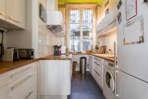 uma cozinha com um frigorífico e uma máquina de lavar e secar roupa em Hamac Suites - Suite Albon Saint Antoine - 4pers em Lyon