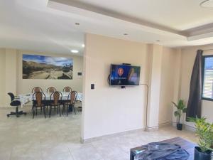 Una sala de estar con una mesa y un televisor en una pared. en DESCANSO JUJEÑO, en San Antonio