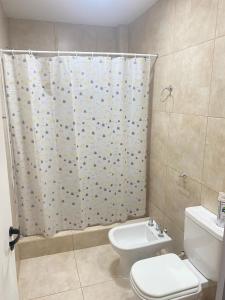 Un baño con inodoro y cortina de ducha. en DESCANSO JUJEÑO, en San Antonio