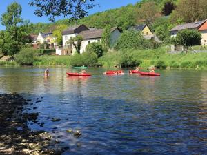 een groep mensen in rode kajaks op een rivier bij Camping du Rivage in Wallendorf pont