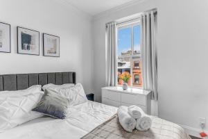a white bedroom with a bed with towels on it at Stylish 2Bd in Brooklyn Heights in Brooklyn