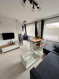 プシェムィシルにあるmieszkanie 2 pokoje, Przemyśl, parterのソファとテーブルのあるリビングルーム +3枚の写真