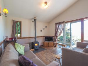 a living room with a couch and a wood stove at Caban Cynnes in Troedyraur