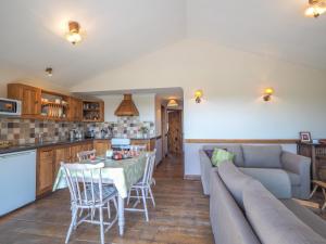 a kitchen and living room with a table and a couch at Caban Cynnes in Troedyraur