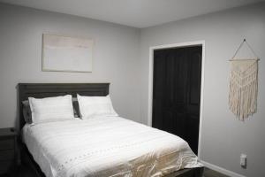 een slaapkamer met een bed met witte lakens en een zwarte deur bij Arctic 415 in Grand Rapids