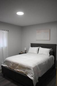 um quarto com uma cama grande e lençóis brancos em Arctic 415 em Grand Rapids