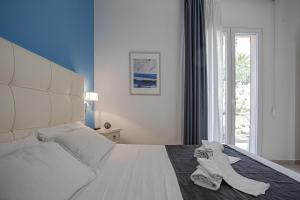 a bedroom with a large white bed with a dog on it at Small Luxury apartments Pool and sea view - Stella Del Mare in Fontane Bianche