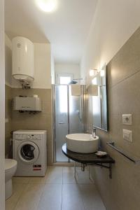 a bathroom with a sink and a washing machine at Small Luxury apartments Pool and sea view - Stella Del Mare in Fontane Bianche