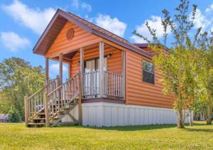 a log cabin with a deck and grass at Cozy 1BR Cabin in Jacksonville in Jacksonville