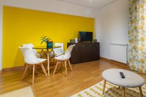 Habitación con mesa, sillas y pared amarilla. en El Palomarcico en Zamora