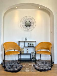 2 orangefarbene Stühle in einem Zimmer mit Spiegel in der Unterkunft Suites Rive Gauche - Région Fontainebleau - Chez Victor in Melun
