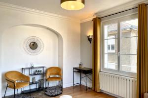 Zimmer mit 2 Stühlen, einem Tisch und einem Fenster in der Unterkunft Suites Rive Gauche - Région Fontainebleau - Chez Victor in Melun