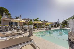 basen w hotelu z leżakami i parasolami w obiekcie Small Luxury apartments Pool and sea view - Stella Del Mare w mieście Fontane Bianche