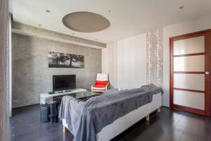 1 dormitorio con 1 cama, TV y escritorio en Hamac Suites - Simon Jallade - 4 people en Sainte-Foy-lès-Lyon