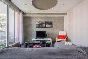 1 dormitorio con 1 cama, TV y silla en Hamac Suites - Simon Jallade - 4 people en Sainte-Foy-lès-Lyon