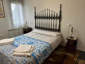 a bedroom with a large bed with a blue and white blanket at Vivienda De Uso Turístico El Nido in La Serrada