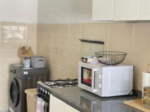 a kitchen counter with a microwave and a stove at louis LBV in Libreville