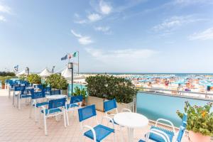 a patio with tables and chairs and a pool at Hotel Bellaria in Bellaria-Igea Marina