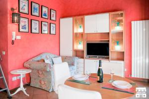 Sala de estar de color rojo con mesa y sofá en THE LOFT by Design Studio, en Bellano