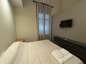 une petite chambre avec un lit et une télévision dans l'établissement Florida 55, à Salta