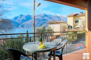 una mesa con una botella de vino en un balcón con montañas en THE LOFT by Design Studio, en Bellano